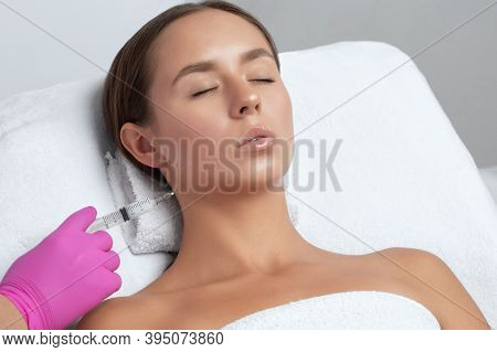 Cosmetologist Makes Lipolytic Injections To Burn Fat On The Chin, Cheeks And Neck Of A Woman Against