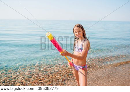 Adorable Active Little Girl At Beach During Summer Vacation