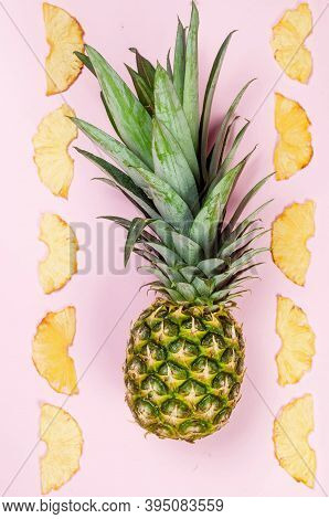 Ripe Juicy Pineapple On Pink Background And Dried Pineapple Wedges Around. Fruit Chips. Healthy Eati