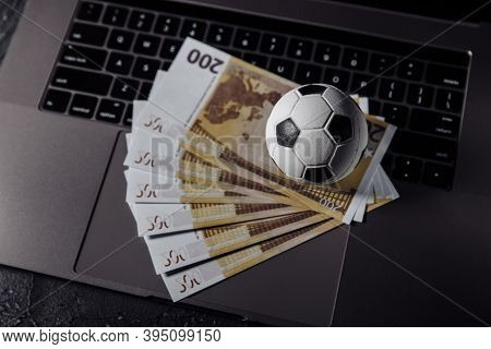Bets, Sports Betting, Bookmaker. Soccer Ball And Money On A Laptops Keyboard Close-up