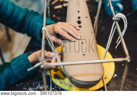 Close-up View Of Female Hands Gently Handling A Clay Whale In Workshop.