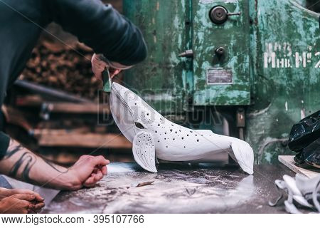 People Carefully Work On A Ceramic Whale In Workshop