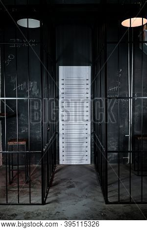 Behind Bars Concept. Police Pre-trial Detention Cell Interior. Dark Prison Interior. Empty Cell.