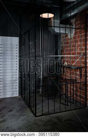 Behind Bars Concept. Police Pre-trial Detention Cell Interior. Dark Prison Interior. Empty Cell.