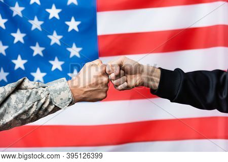 Cropped Of Soldier Fist Bumping With Civilian Man Near American Flag On Blurred Background
