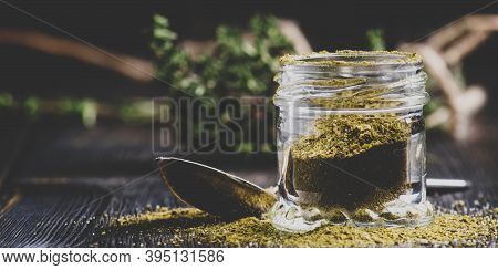 Traditional Caucasian Seasoning With Herbs And Spices, Khmeli Suneli In A Glass Jar, Black Backgroun