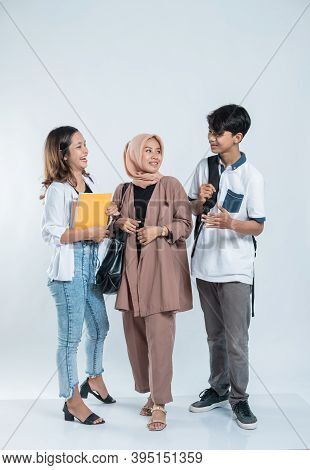 Portrait Of Conversation College Friends Carrying A Bag And Book