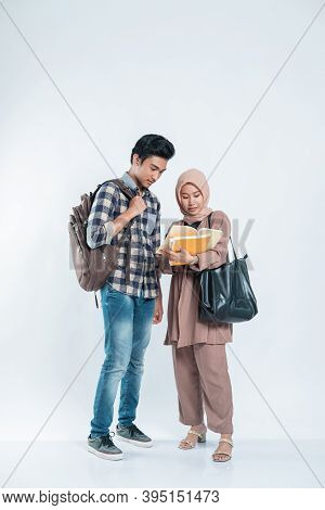 Portrait Of Beautiful Muslim Women Explaining Project On Book To His Partner