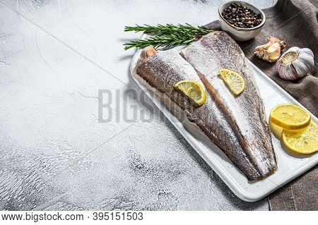 Fresh Raw Hake Fish Fillet With Pepper And Lemon. White Background. Top View. Copy Space