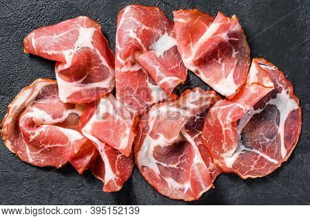 Italian Rolled Bacon Pancetta Piacentina. Pork Meat. Black Background. Top View