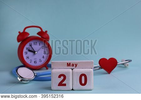 20st May. White Wooden Calendar Blocks With Date, Clock And Stethoscope On A Blue Pastel Background.