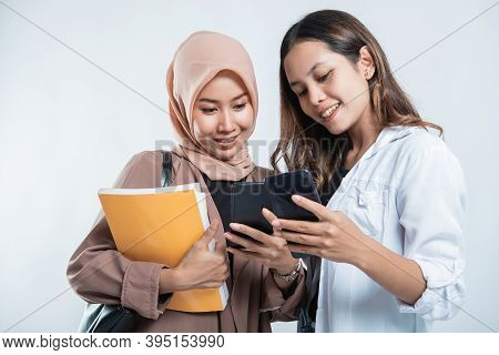 Portrait Of Happy University Youth Carrying Bags And Discussion Looking At Cell Phones
