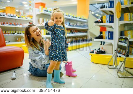 Mother and little baby choosing shoes, kid's stor