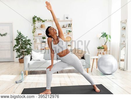 Fit Black Woman Stretching Her Body On Yoga Mat During Her Home Workout. Sporty African American Lad