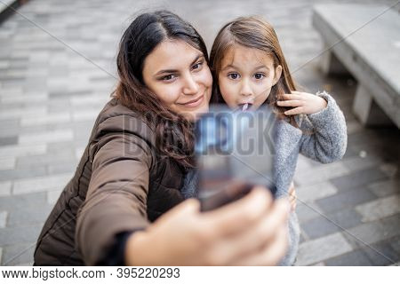Mother And Daughter Taking A Selfie While Making Funny Faces