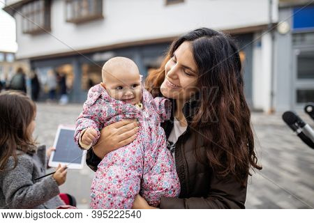Happy Beautiful Mother Smiling And Holding Her Baby Daughter