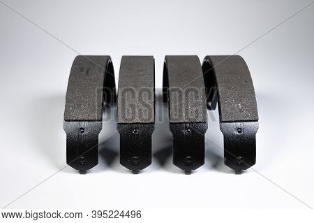 New Set Of Four Brake Pads For Drum Brakes On A Gray Background