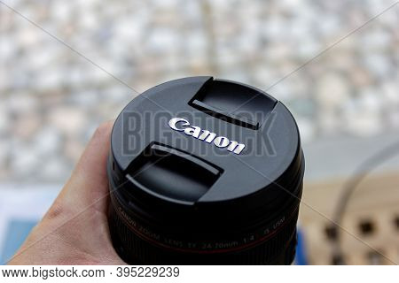 Brecht, Belgium - June 20 2020: A Portrait Of Someone Holding A Canon L Lens With A Lens Cap With Th