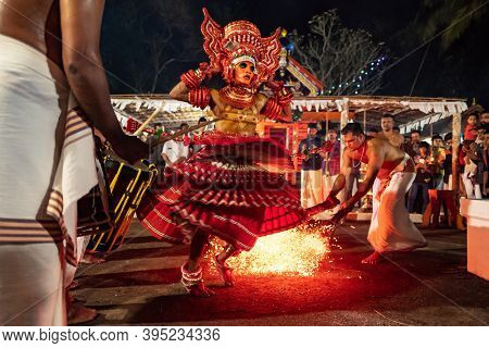 Payyanur, India - December 4, 2019: Theyyam artist perform with fire during temple festival in Payyanur, Kerala, India. Theyyam is a popular ritual form of worship in Kerala, India