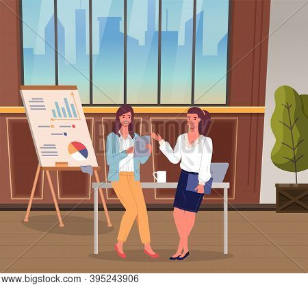 Two Businesswomen Talking In The Office. Women Leaning At Table With Computer And Cup. Flipchart Wit