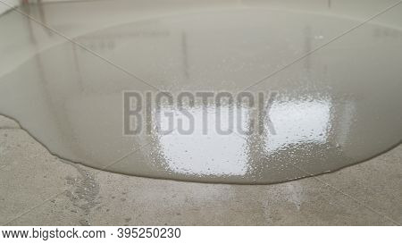 The Self-leveling Floor Is Poured Onto The Floor. The Worker Pours The Solution From The Self-leveli