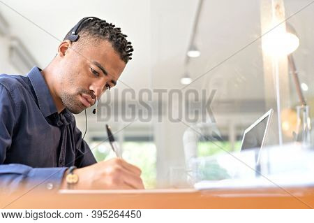 Office-worker with headset on, attending online business conference