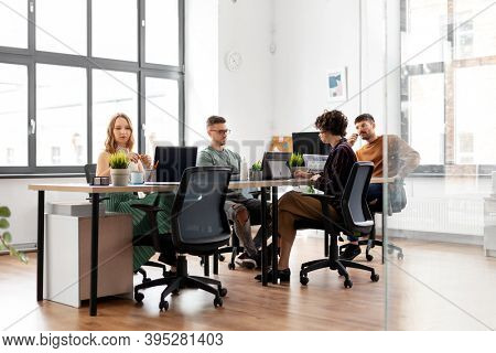 business, people and corporate concept - team of startuppers or designers working at office