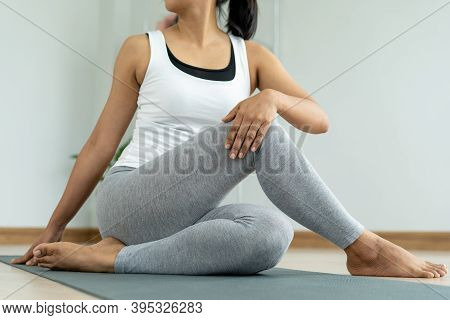 Young Woman Doing Stretching Exercises At Home In Relaxation. Women Are Doing Seated Twist Exercises