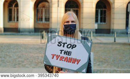 Young Woman In Protective Mask Calling To Stop The Tyranny By Holding Steamer. Protest Walk In The C