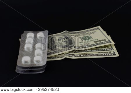 Standards Of Round White Pills And Several Banknotes On A Black Background.