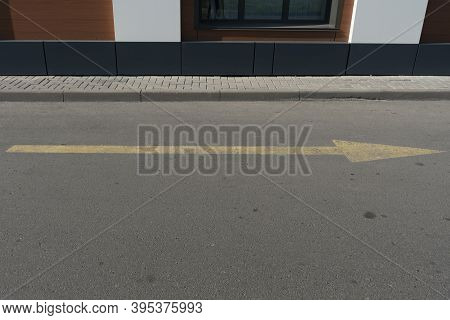 Yellow Arrow On The Asphalt Indicating Traffic.