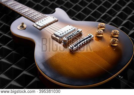 Sunburst Electric Guitar Lying On Acoustic Foam Panel Background