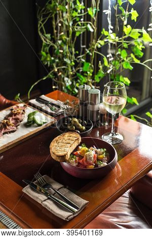 Salad With Fresh Vegetables And Cottage Cheese In Bowl And Bread Toast On Wooden Table