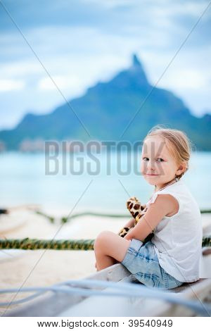 Lille pige på ferie på Bora Bora island med Otemanu mountain silhuet på baggrund