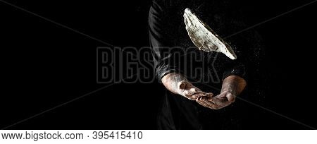 Pizza Cook's Hand With Dough, Powdery Flour Flying Into Air. Chef Hands With Flour In A Freeze Motio
