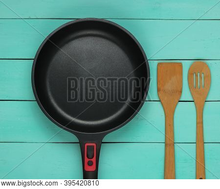 Frying Pan With A Non-stick Coating With Cooking Spatula On Blue Wooden Background. Cooking Equipmen