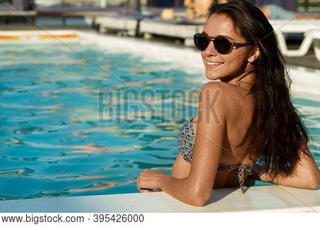Gorgeous Brunette Young Woman Wearing Sunglasses Smiling To The Camera, While Relaxing In The Sweemi
