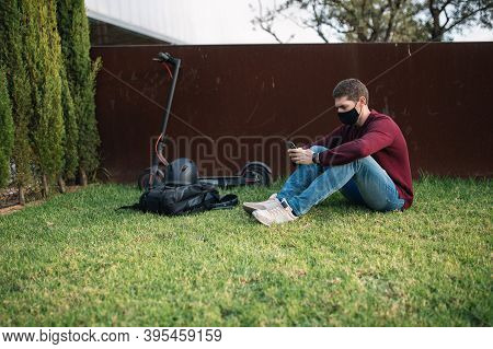 Young Person Using A Mobile Phone With An Electric Skate.
