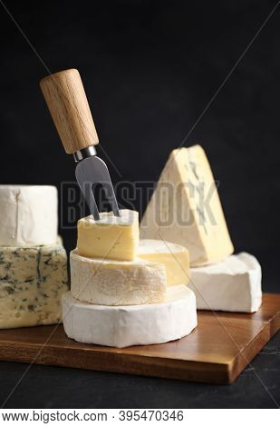 Different Types Of Cheese And Fork On Black Table