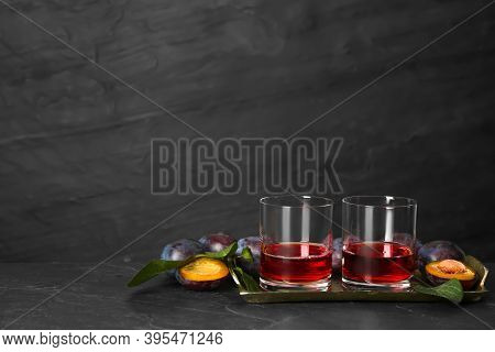Delicious Plum Liquor And Ripe Fruits On Black Table. Homemade Strong Alcoholic Beverage