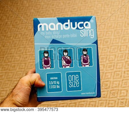 Paris, France - Nov 11, 2020: Pov Male Hand Holding Package Of New Manduca Sling For Baby - Isoalted