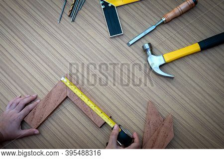 Close Up View Of A Woman's Hands Measuring Wooden Plank With A Tape Measure With A Set Collection Of
