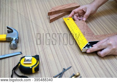 Female Hands Using A Try Square To Check That The Woodworking Corners Are Square With A Set Collecti