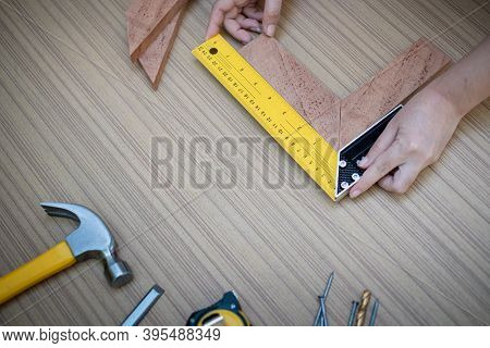 Female Hands Using A Try Square To Check That The Woodworking Corners Are Square With A Set Collecti