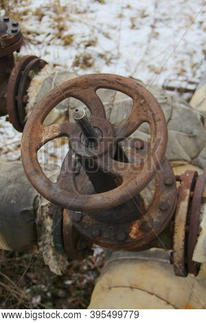 Old Damaged And Rusty Iron Oil Pipe Valve Wheel. Metal, Pipeline And Mechanic Concept. An Old Iron V