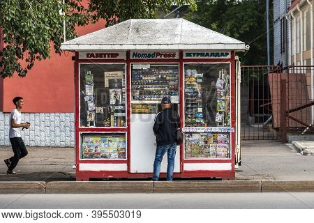 Pavlodar, Kazakhstan - July 27, 2020: Kiosk With Man Buying, In Pavolodar With Running People On A S