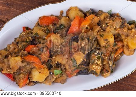 Traditional Italian Vegetable Stew With Potatoes, Eggplants, Tomatoes And Peppers In An Oval Plate O