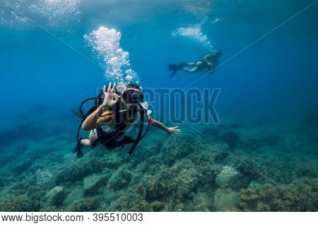 August 20, 2020. Anapa, Russia. Happy Couple Of Scuba Divers Glides Underwater In Transparent Blue S