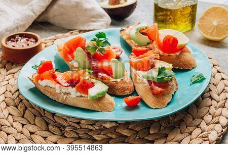 Smoked Salmon Sandwich With Cream Cheese, Lemon, Avoado And Tomato On Gray Background.