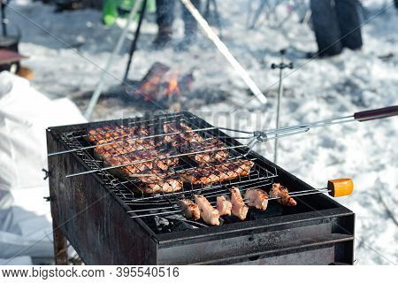 Winter Barbecue Outdoors, Grill Steak And Fork With Meat Over Hot Coals In A Bbq At Campside Cookout